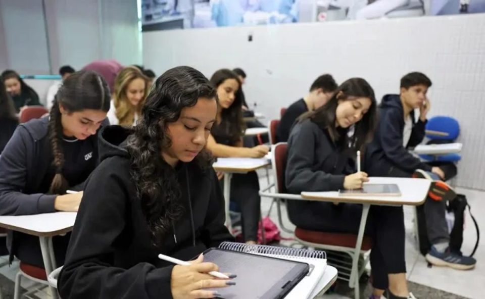Foto de uma sala de aula com estudantes escrevendo em seus cadernos. Imagem ilustrativa para matéria programa Talentos Paraná no Mundo que terá as suas inscrições encerradas no próximo sábado (18)