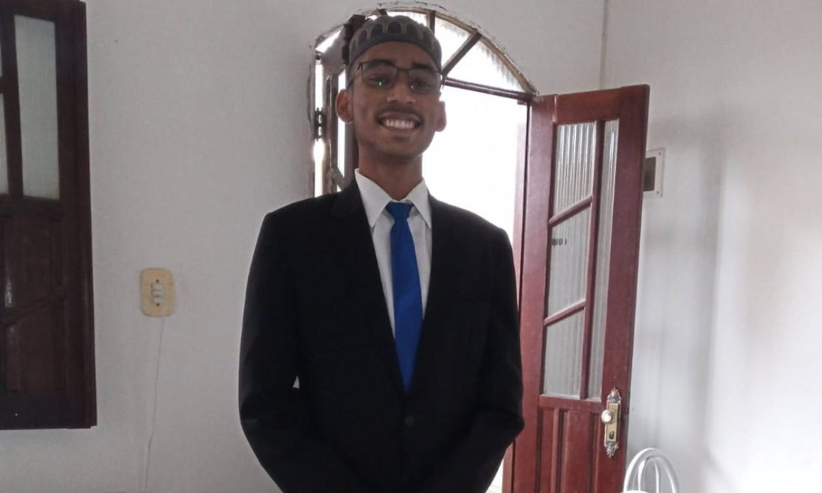 Jovem baiano desaparece em Curitiba e está há quase um ano sem dar notícias a familiares. Imagem mostra uma foto do desaparecido. Ele é negro, usa um terno preto, camisa branca e gravata azul.