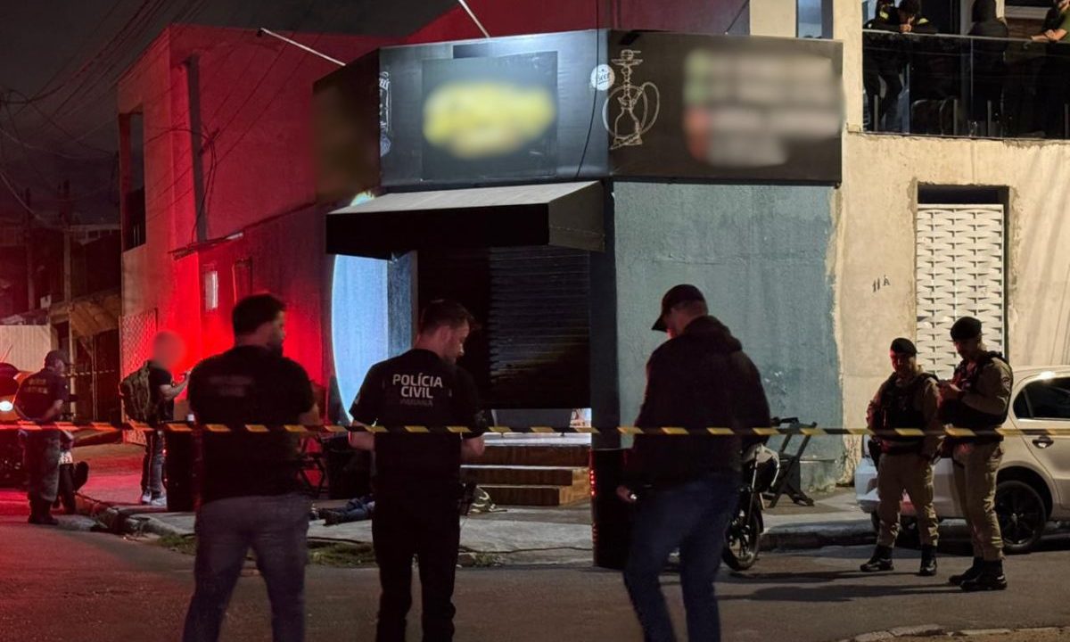 foto do local onde o homem foi morto a tiros em frente a bar em curitiba. na imagem aparece equipes da polícia militar e civil