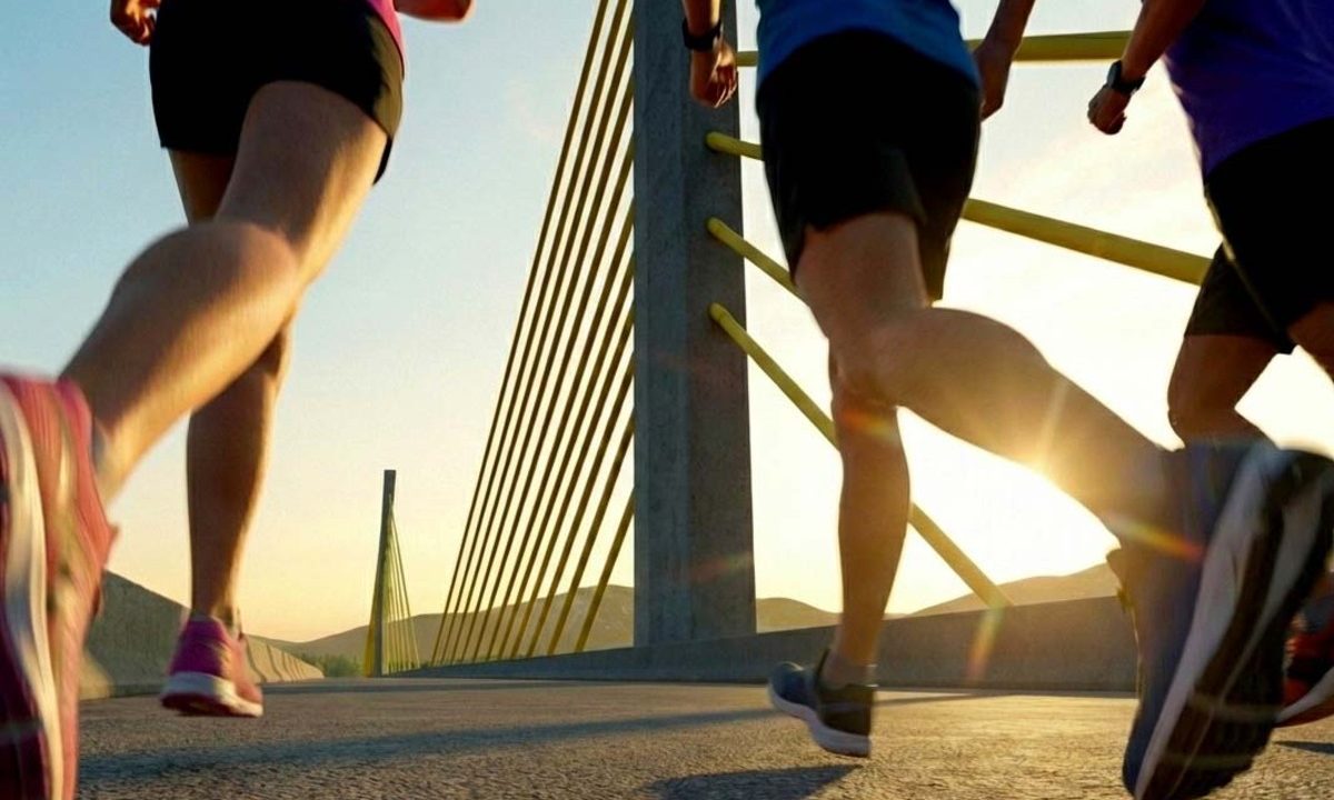 Pessoas correndo na Ponte de Guaratuba, ilustrando o início da entrega de kits para a Maratona Internacional do Paraná.