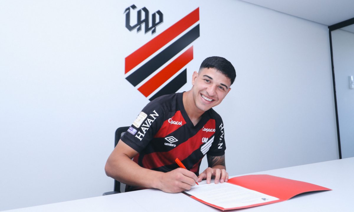 Foto de Lucas Esquivel assinando a renovação de contrato com o Athletico