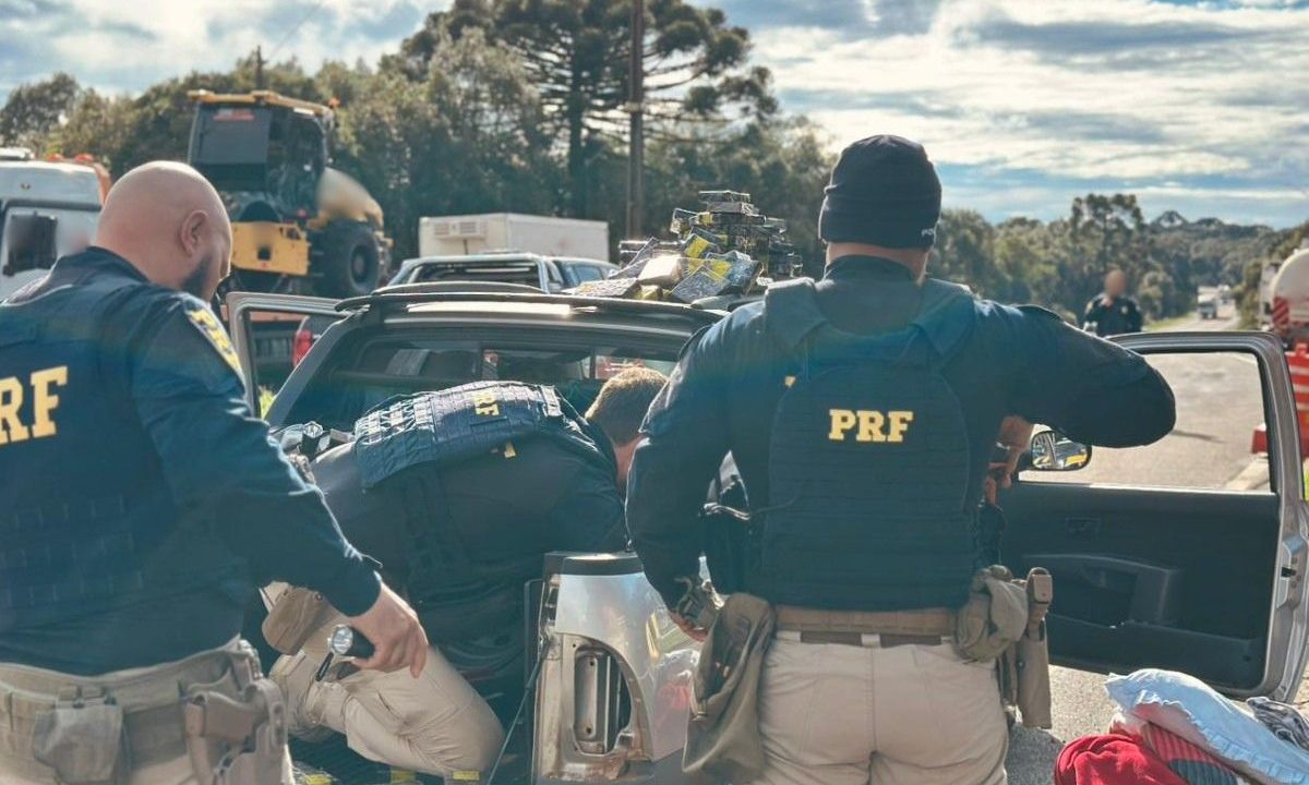 Policiais rodoviários federais durante abordagem de um carro na BR-277, que transportava uma carga de iPhone e outros celulares.