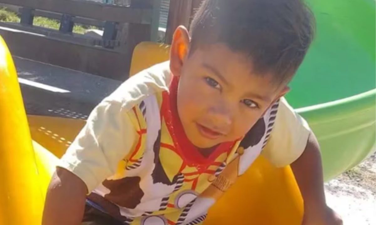 Imagem mostra o menino morto com golpes na cabeça. A mãe e padrasto da vítima foram presos. Imagem mostra a criança com camiseta branca, com desenhos coloridos. Ele é moreno, com cabelo liso.