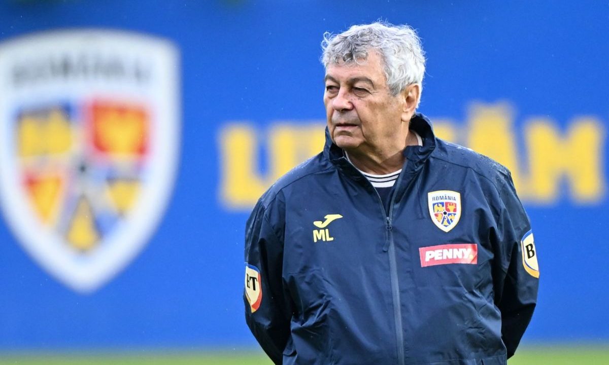 Mircea Lucescu, treinador da Seleção Romena, aparece em pé durante atividade no campo, vestindo agasalho azul com o escudo da Romênia, em imagem que ilustra sua trajetória no futebol europeu e ligação com jogadores brasileiros