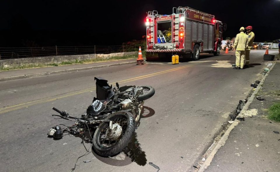 Imagem mostra a moto jogada na via onde o motorista com suspeita de embriaguez provocou diversos acidentes em Colombo. Atrás da foto tem um caminhão do Copor de Bombeiros e bombeiros.