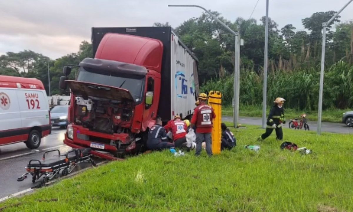 Socorristas atendendo motorista que foi ejetado de caminhão ao lado da estrada