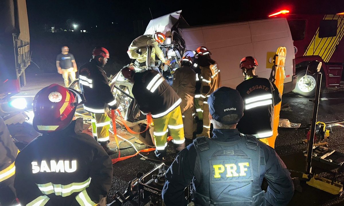 Foto tirada durante a noite mostra van com a frente destruída após colidir contra a traseira de uma carreta bitrem na BR-376; uma mulher ficou presa às ferragens