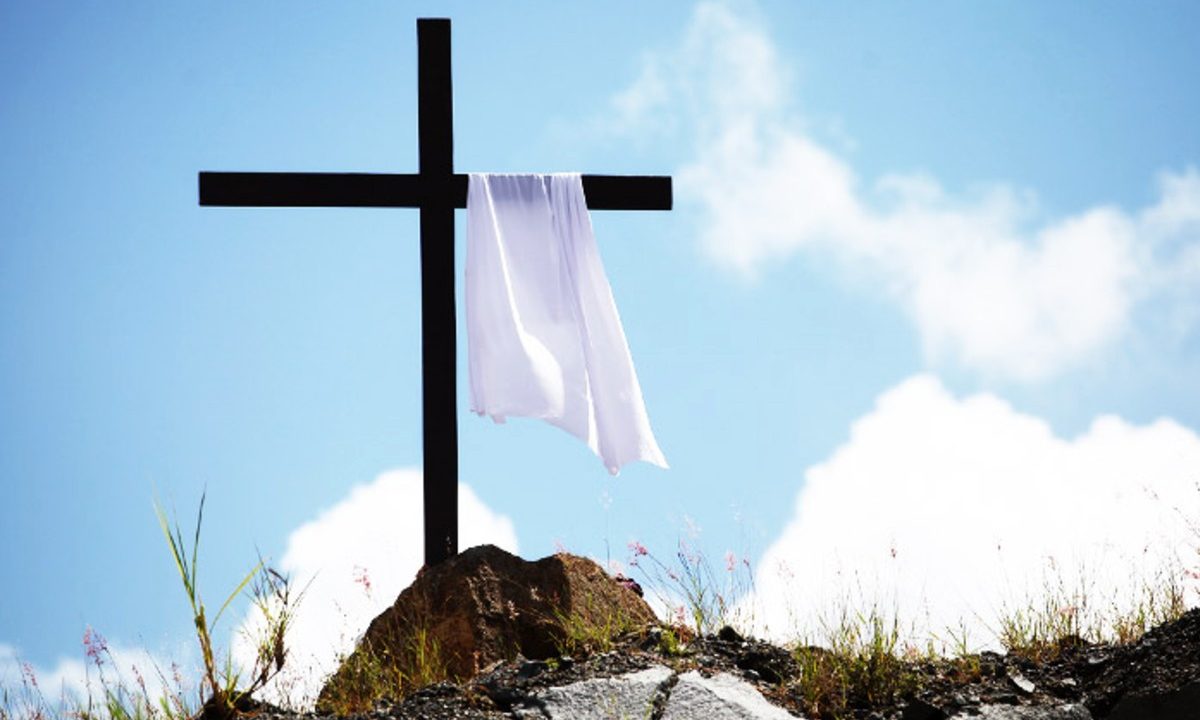 Cruz vazia, com um pano, no alto de um morro, representando a ressurreição de Cristo com o céu azul. O tema é celebrado nas Missas de Semana Santa em Curitiba durante o feriado que antecede a Páscoa