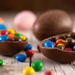 Imagem ilustrativa mostra um ovo de páscoa cheio de confetes. O ovo é marrom, de chocolate. Os confetes são coloridos. A ideia é ilustrar a páscoa em curitiba.