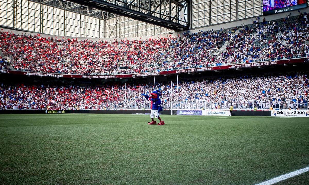 Mascote em campo diante de arquibancadas cheias na Arena da Baixada durante jogo da Segundona do Paranaense com grande público presente