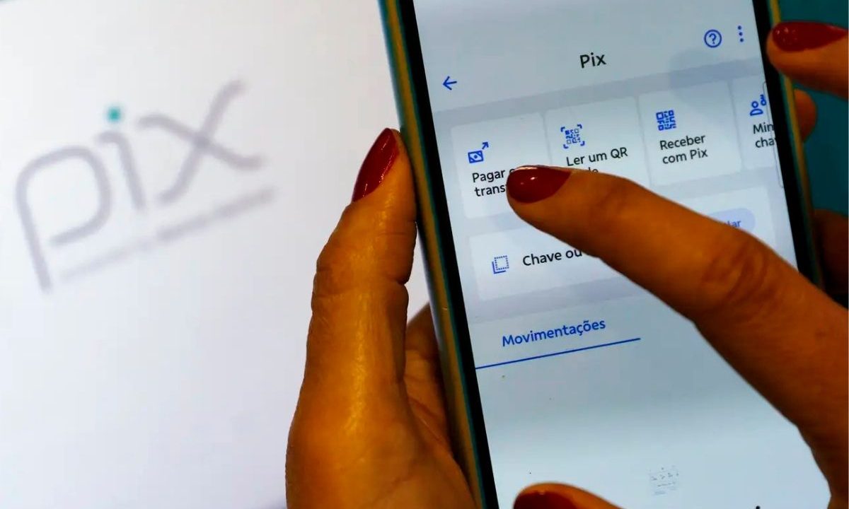 Às vésperas da delcaração do Imposto de Renda 2026, as pessoas têm dúvidas sobre o Pix, se precisar declarar ou não. A imagem mostra uma mulher utilizando o celular e fazendo transferências via Pix.