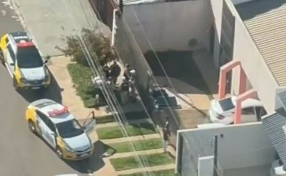 Imagem mostra equipes policiais identificando policial militar, preso por sequestro relâmpago.