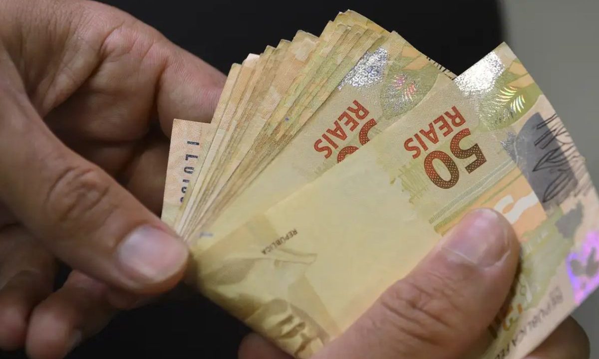 Homem segurando dinheiro para representar prêmio da Quina 7014