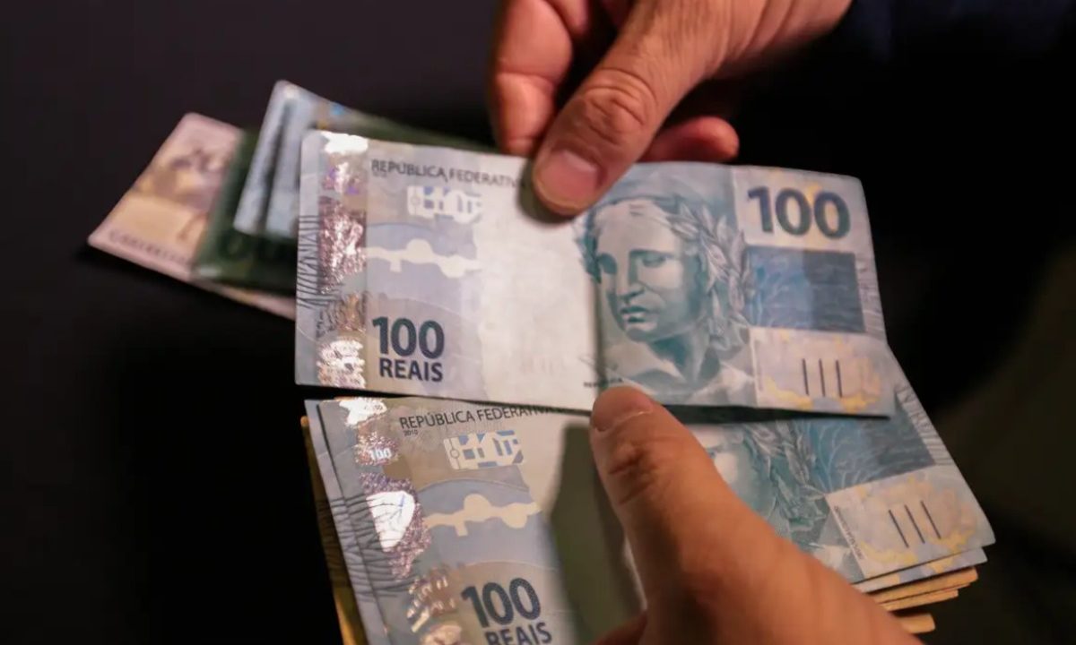 Foto de mão contando cédulas de R$ 100; imagem usada para ilustrar matéria com o resultado oficial da Lotofácil 3655
