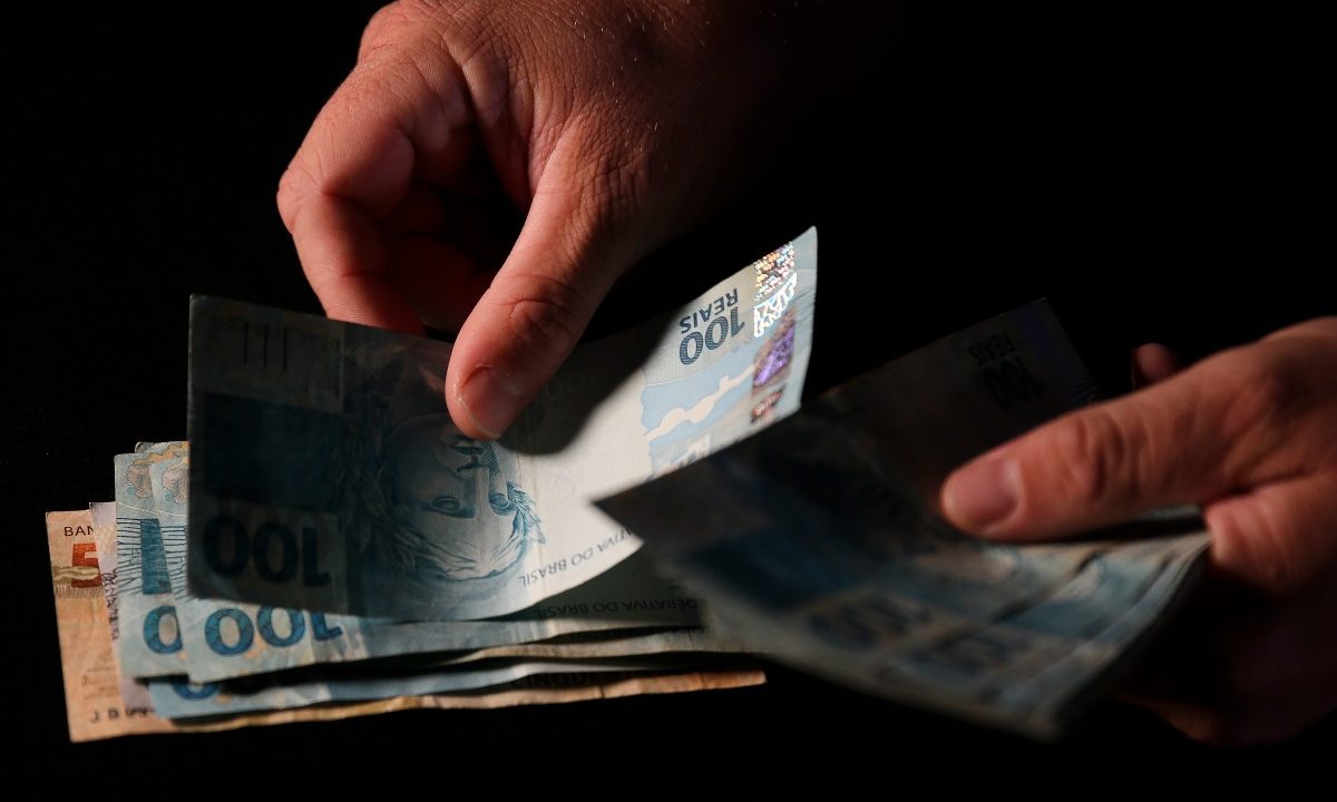 Foto de mão contando dinheiro para ilustrar matéria jornalística sobre os ganhadores no resultado da lotofácil 3656