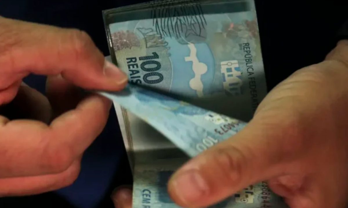 Foto de uma mão contando cédulas de reais; imagem usada para ilustrar a matéria de resultado da lotofácil 3650