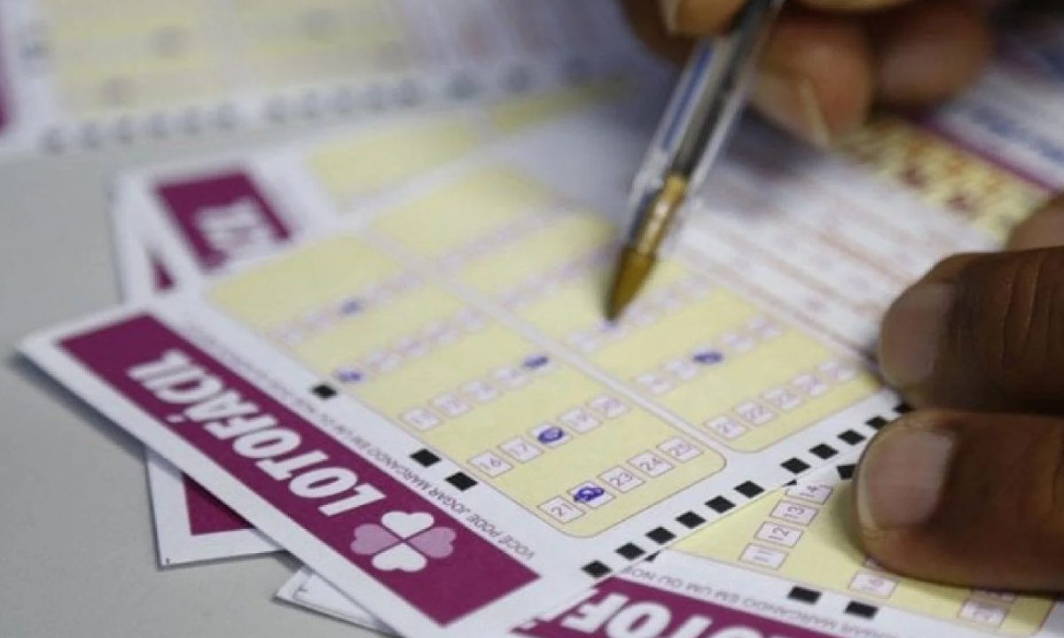 Foto de uma mão preenchendo bilhetes com o resultado da Lotofácil de ontem, em referência ao resultado do sorteio 3696.