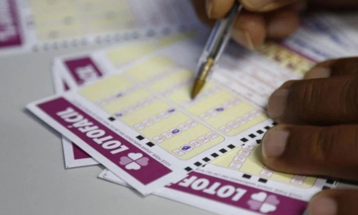 Mão preenchendo volante da Lotofácil 3670