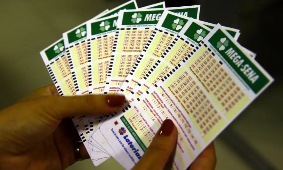 Foto de mão preenchendo bilhete de loteria após sair o resultado da Mega-Sena 3002