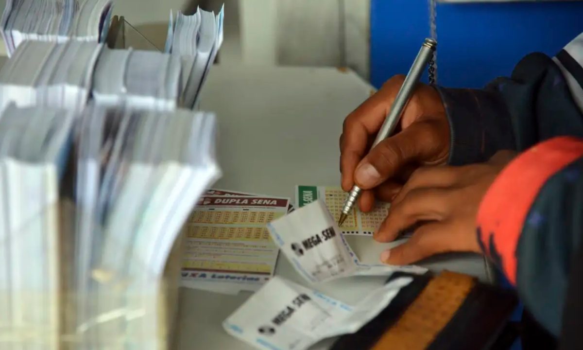 Foto de mão preenchendo bilhete de loteria; imagem para ilustrar resultado da mega-sena 2996