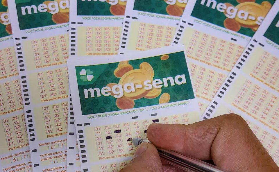 Mão preenchendo volante da Mega-Sena 2999