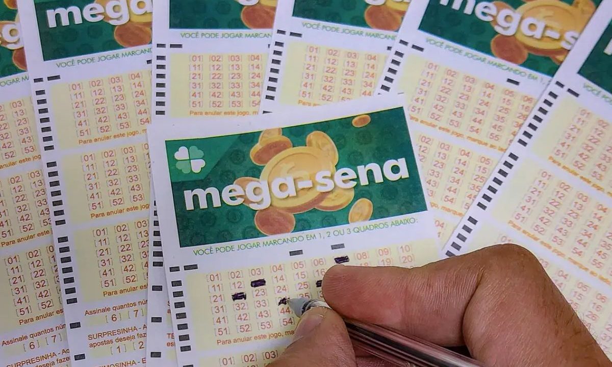 Mão preenchendo volante da Mega-Sena 3000