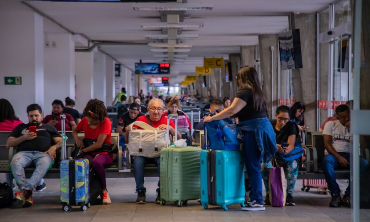 Pessoas sentadas na Rodoviária de Curitiba, esperando o embarque; 21 mil pessoas são esperadas no local durante o feriado de Tiradentes
