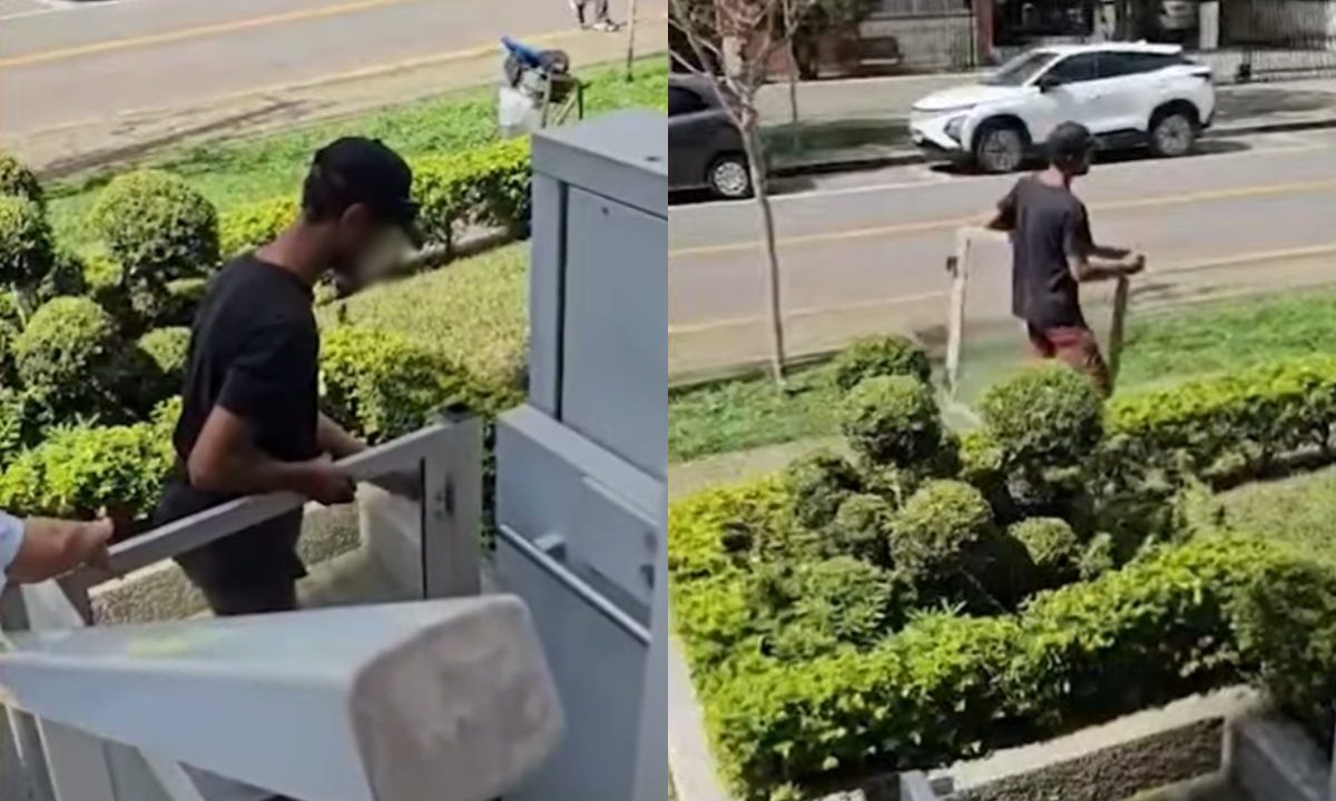 Homem retira estrutura metálica de elevador em frente a condomínio no Centro de Curitiba e deixa o local a pé.