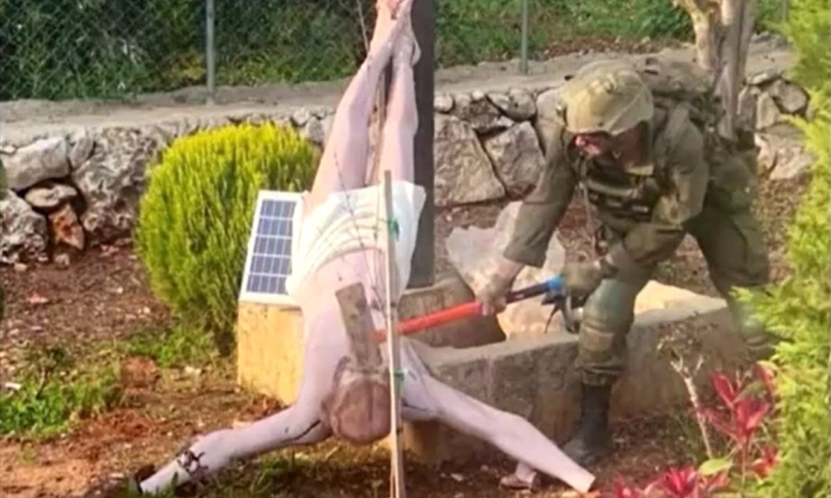 Soldado de Israel golpeando estátua de Jesus Cristo com um machado