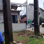 Telhado de oficina desabad e pessoas em volta