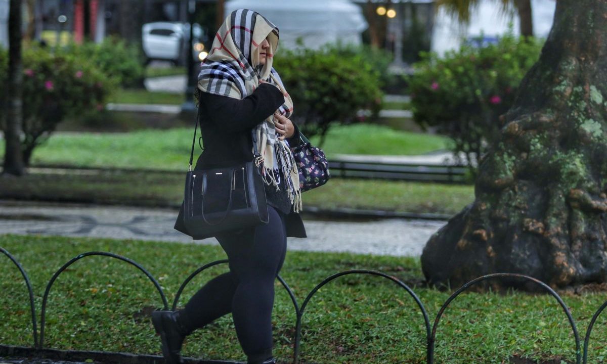 mulher andando com cachecol para ilustrar o frio e as temperaturas baixas no Paraná