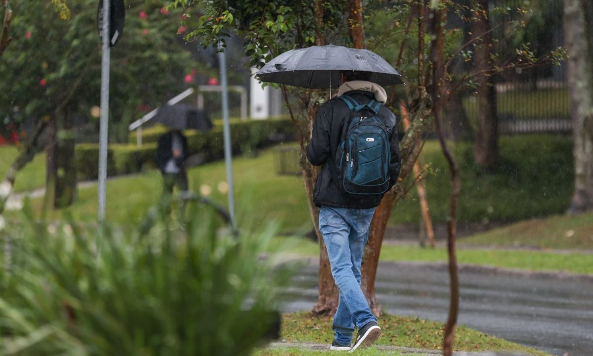 foto de uma pessoa andando na chuva para ilustrar o avanço do ciclone e previsão do tempo em curitiba