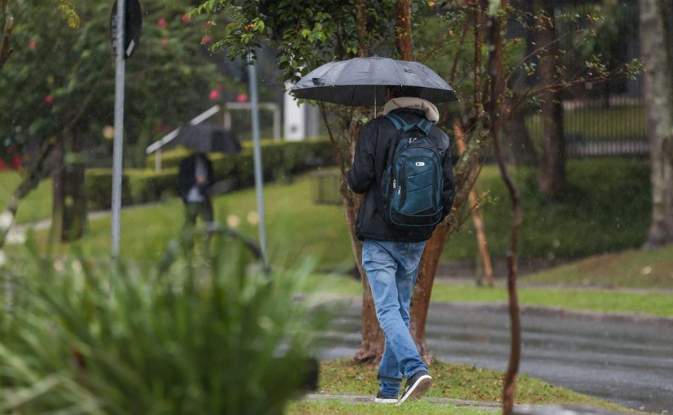 foto de uma pessoa andando na chuva para ilustrar o avanço do ciclone e previsão do tempo em curitiba 