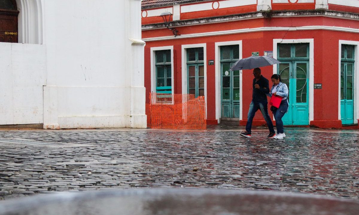 foto de pessoas andando na chuva para ilustrar avanço de ciclone e previsão do tempo em curitiba