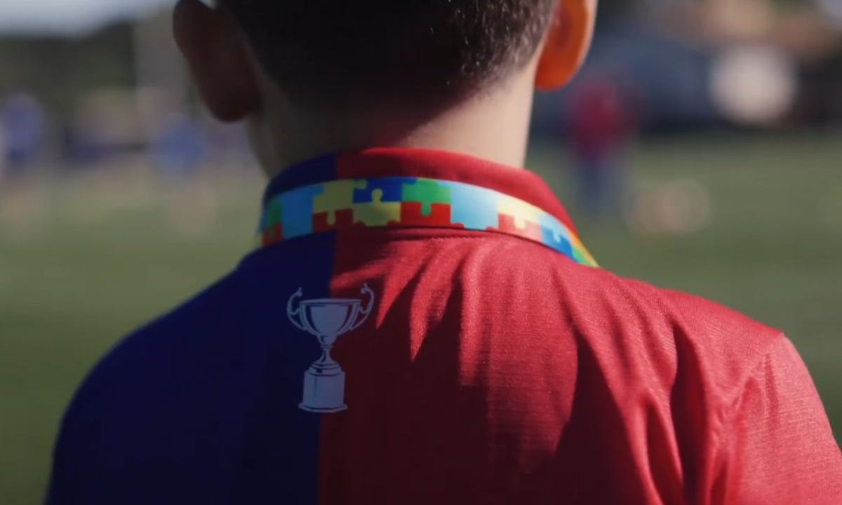 Torcedor mirim Pedro com camisa do Paraná Clube e cordão quebra-cabeças colorido estampado no pescoço antes de viajar 840 km para assistir jogo em Curitiba