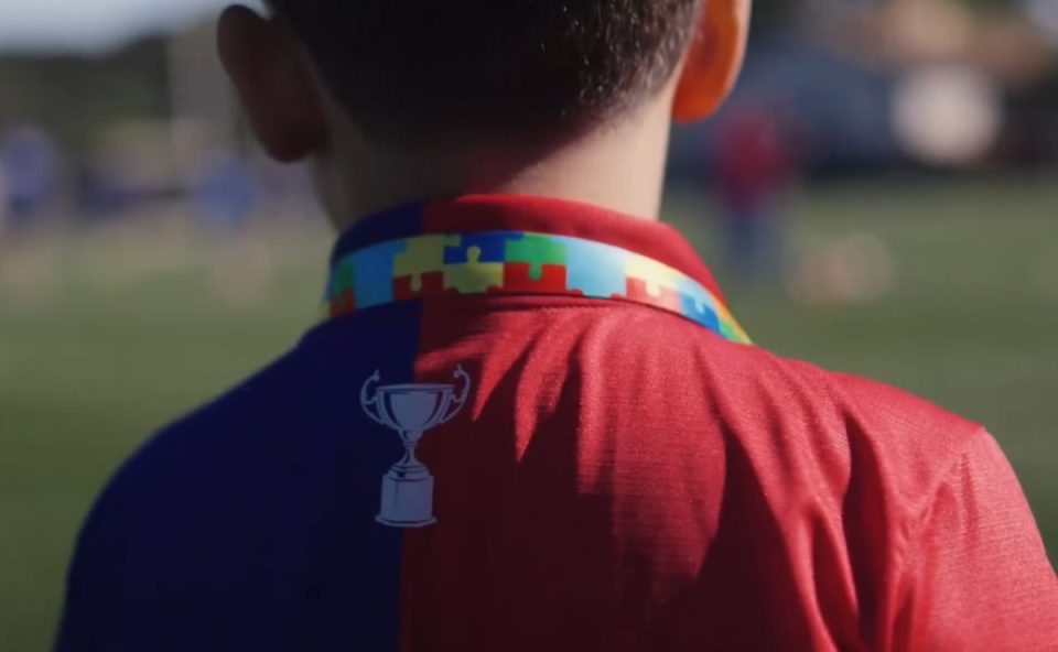 Torcedor mirim Pedro com camisa do Paraná Clube e cordão quebra-cabeças colorido estampado no pescoço antes de viajar 840 km para assistir jogo em Curitiba