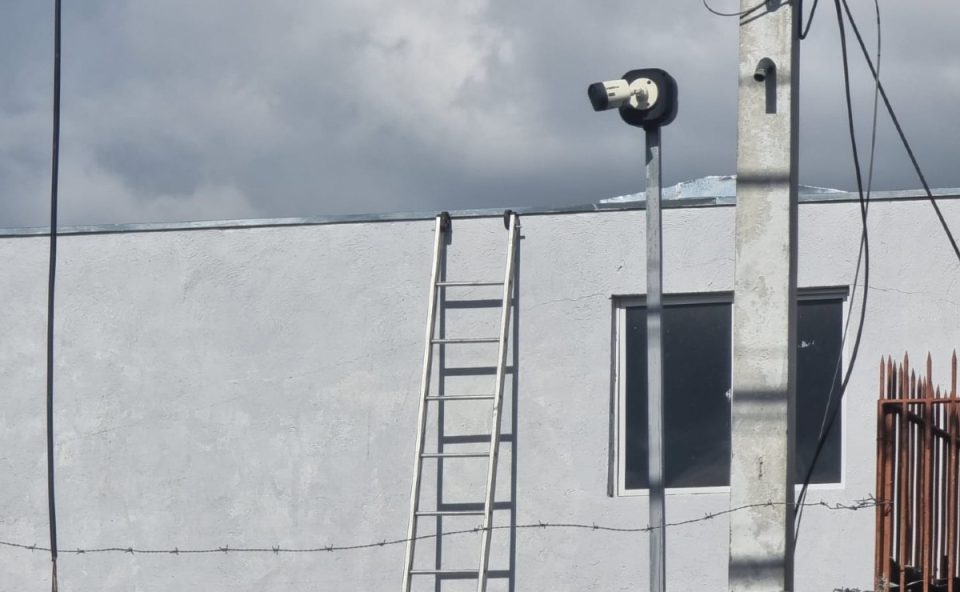Escada apoiada em parede e telhado, onde trabalhador caiu durante manutenção no bairro Lindóia, em Curitiba.