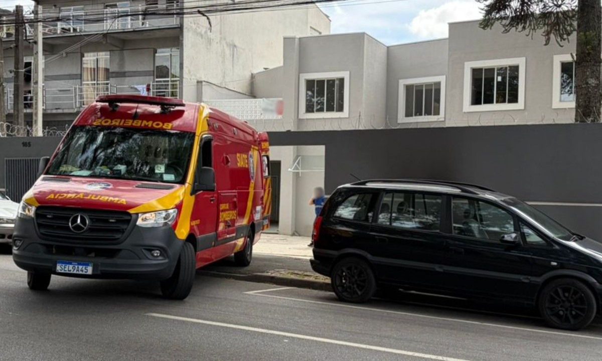 Ambulância do Corpo de Bombeiros e carro preto em frente a um sobrado com pontos comerciais onde trabalhador caiu de telhado no Prado Velho.