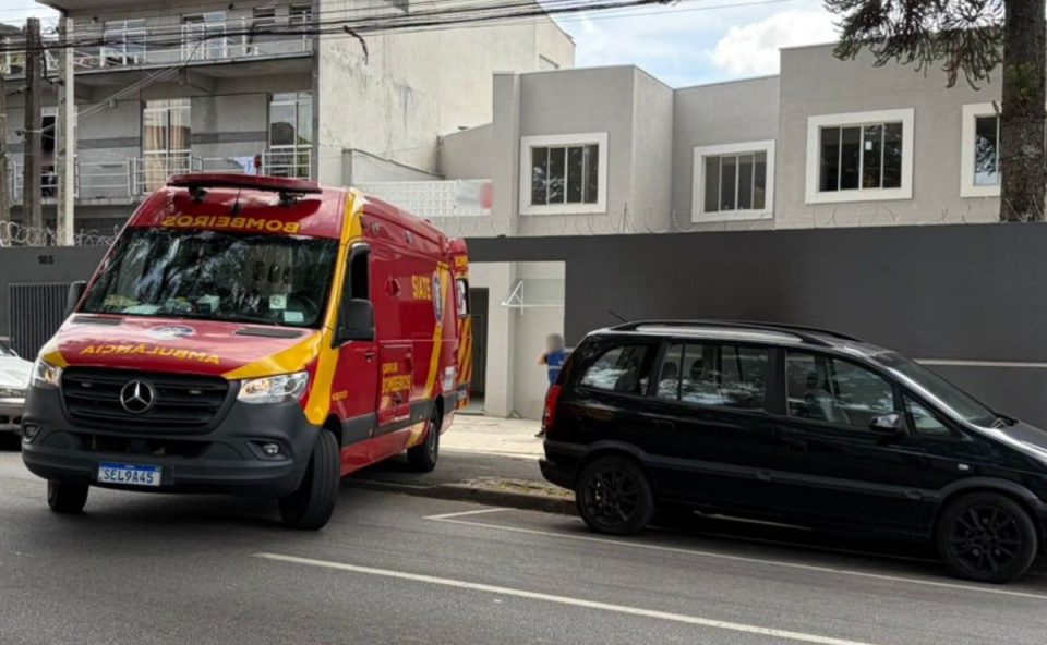 Ambulância do Corpo de Bombeiros e carro preto em frente a um sobrado com pontos comerciais onde trabalhador caiu de telhado no Prado Velho.