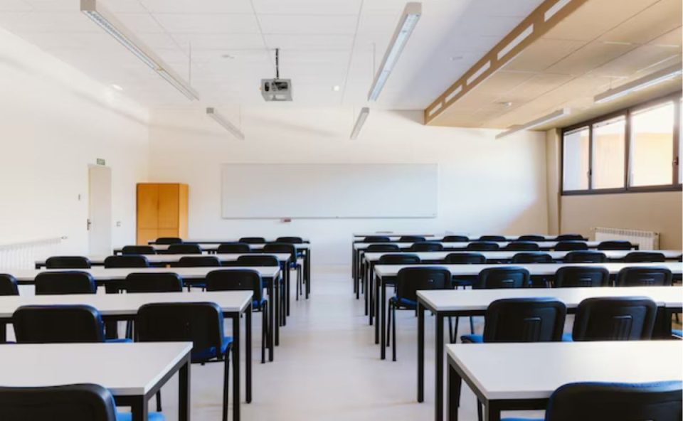 A imagem mostra uma sala de aula vazia, representando as mais de 17 meninas que denunciaram abuso sexual em uma universidade no Paraná