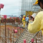 Operários trabalhando em um canteiro de obras com ferragens expostas; imagem ilustrativa para reportagem sobre a crítica ao uso FGTS no programa Desenrola.