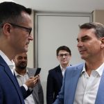 Deltan Dallagnol, do partido Novo, e o senador Flávio Bolsonaro conversam; imagem ilustra a nota do Novo Paraná sobre o momento em que Zema critica o senador pelo caso do Banco Master.