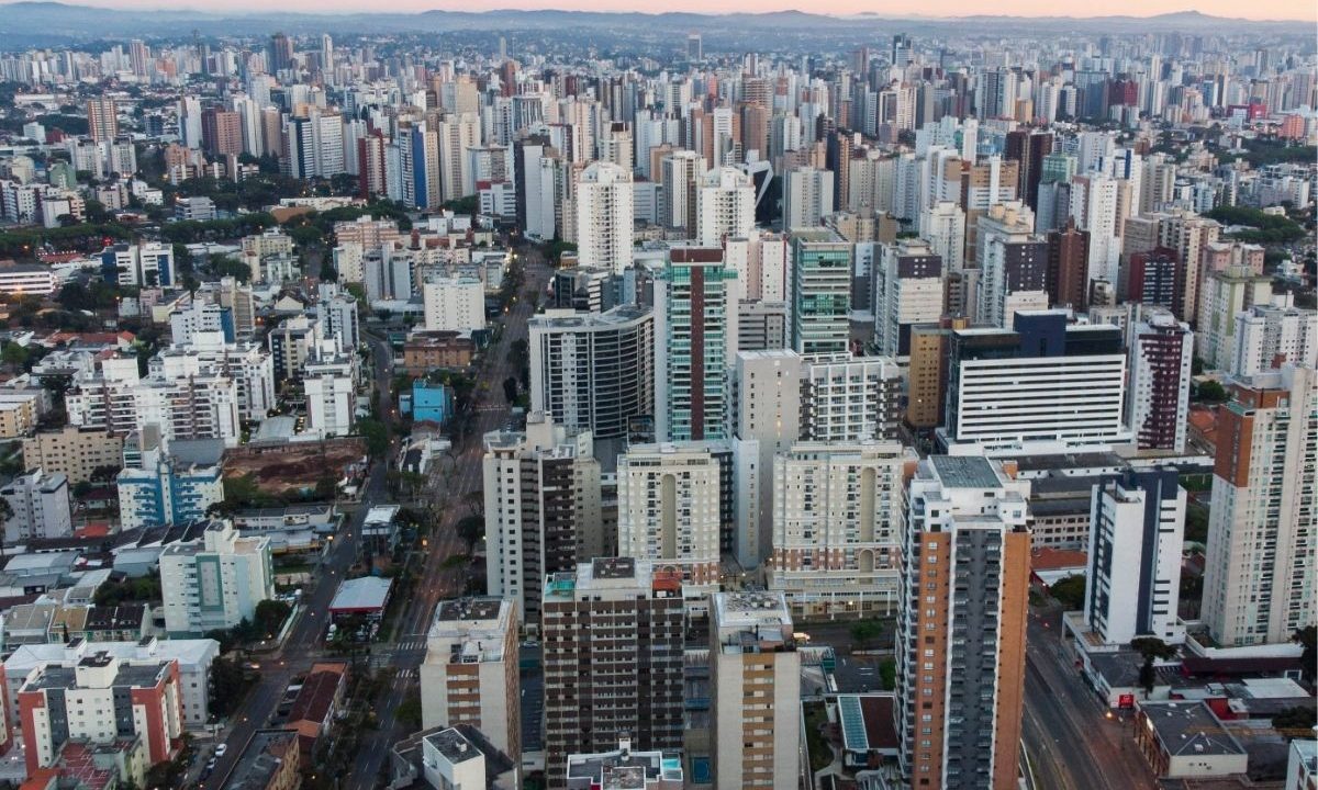 Vista aérea de Curitiba mostrando o planejamento urbano e prédios residenciais. A cidade subiu no ranking de qualidade de vida entre as capitais brasileiras no IPS 2026.