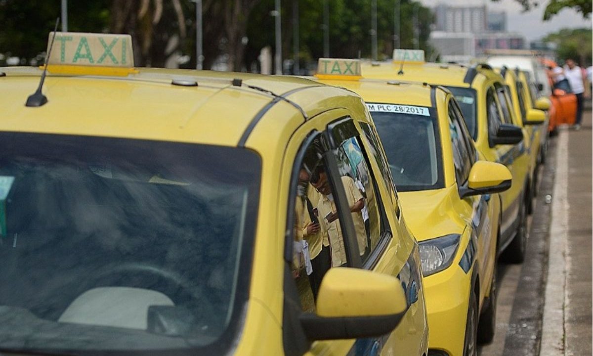 Fila de táxis amarelos estacionados em uma via pública. Imagem ilustrativa para reportagem sobre financiamento de veículos para motoristas de aplicativo e táxi pelo programa Move Brasil.