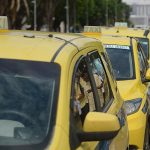 Fila de táxis amarelos estacionados em uma via pública. Imagem ilustrativa para reportagem sobre financiamento de veículos para motoristas de aplicativo e táxi pelo programa Move Brasil.