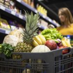 Pessoa com carrinho cheio no supermercado representando os preços pós fim da escala 6x1