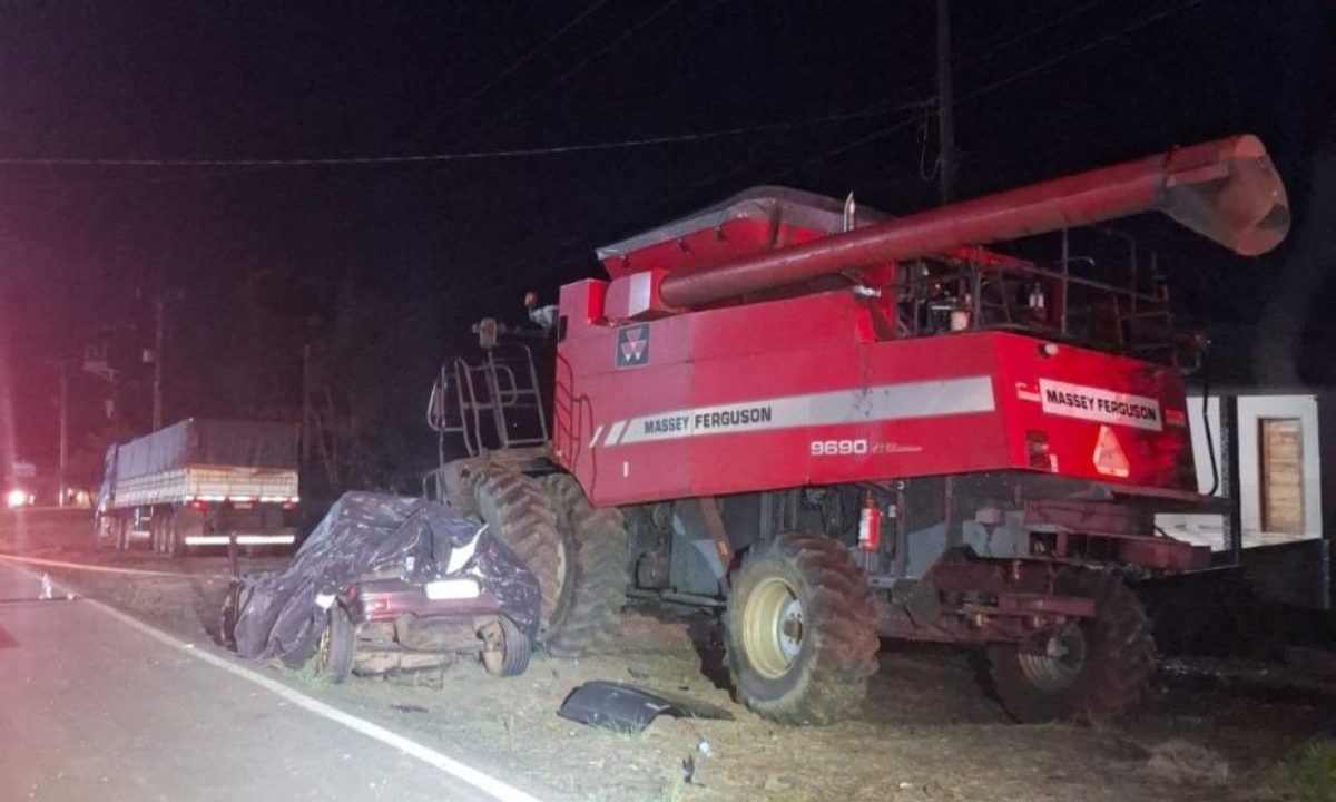 Na imagem, uma máquina agrícola da marca Massey Ferguson aparece parada às margens da rodovia após o acidente que resultou na morte de um jovem de 19 anos