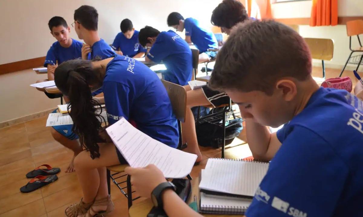 Estudante em sala de aula lendo o seu caderno. Imagem ilustrativa para matéria: Enem facilita inscrição de alunos concluintes do ensino médio em 2026