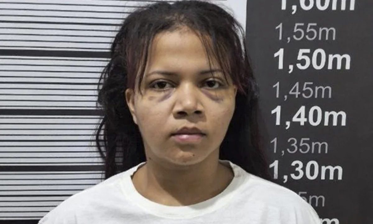 N registro aparece a garota de programa Maria Elane da Silva Morais, de pele morena, cabelo curtos, após ser presa pela polícia, vestindo uma camisa branca, depois que o marido esfaqueou seu cliente após sexo no carro
