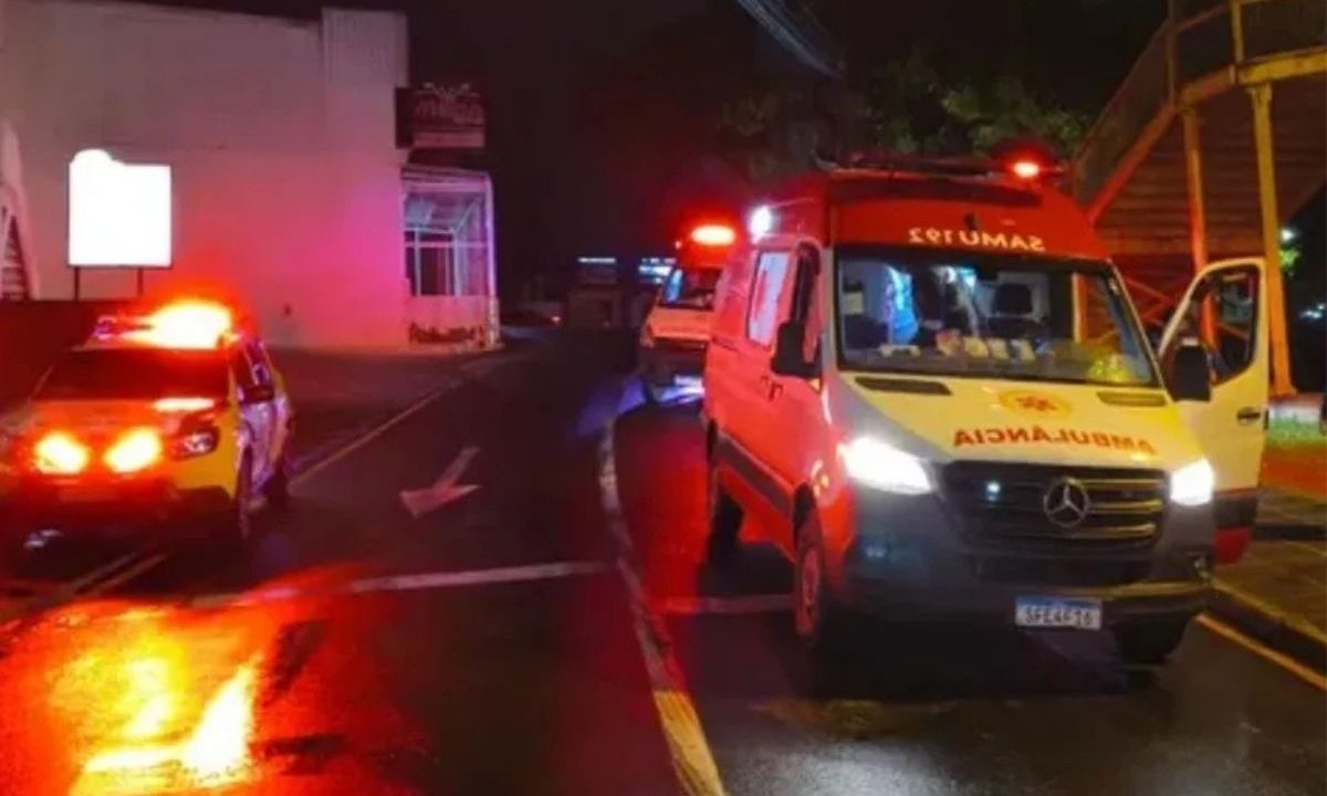 Ambulância do Samu e viatura da Polícia Militar com giroflex ligados à noite em Ponta Grossa. Caso envolve suspeito de tornozeleira eletrônica.